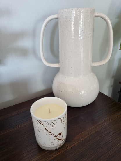 Aromatherapy candle in marbled tumbler with lid.